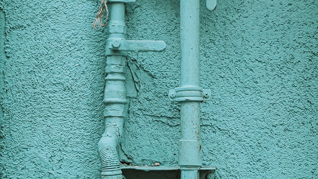 A gas meter and its pipework on the wall of a house. Everything downstream of it is the owner's to size, run and prove.