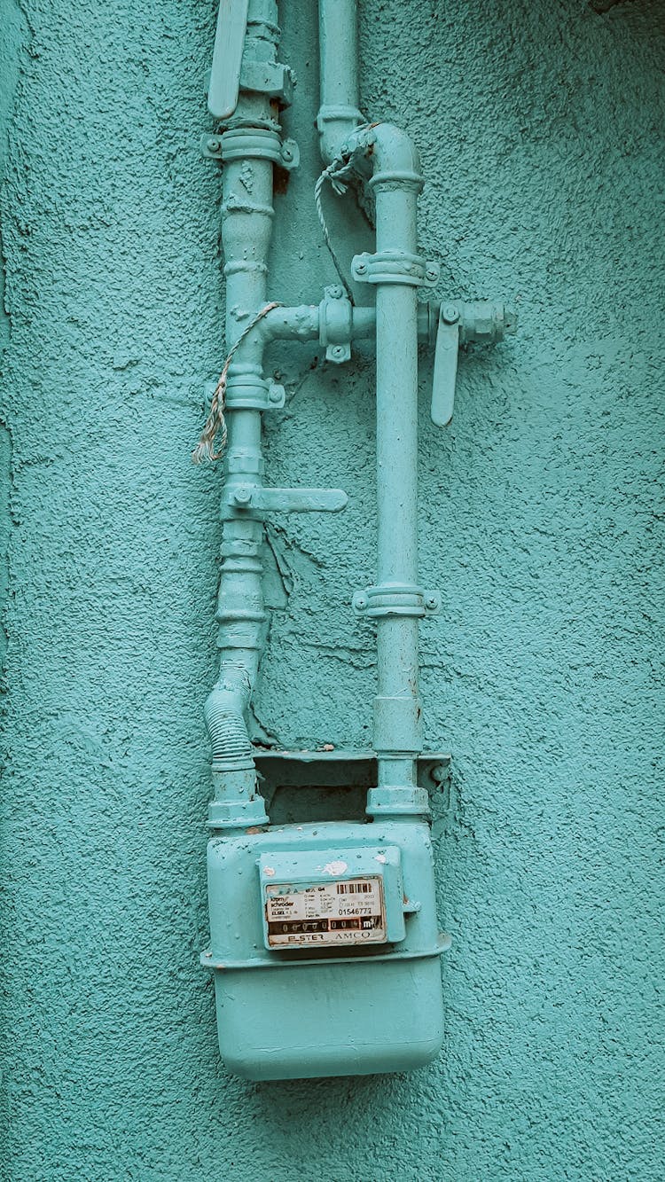 Pipes And Gas Meter Painted In The Color Of The House