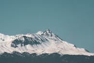 在晴朗的蓝天下，冬天欣赏雪山的壮丽景色