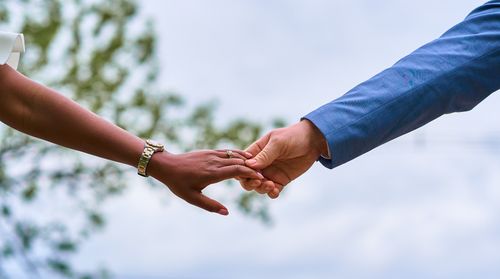 Free An elegant moment of a couple gently holding hands outdoors, symbolizing love and connection. Stock Photo