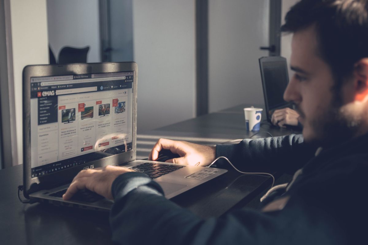 Professional using a laptop to manage an online marketplace listing