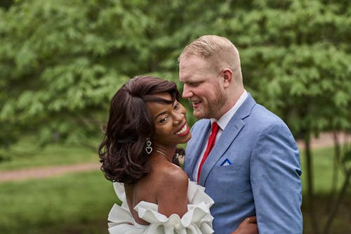 Bride and Groom Standing in a Park, Hugging and Smiling 