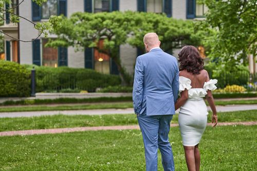 Free A newlywed couple elegantly walks through a lush green park, showcasing love and style. Stock Photo