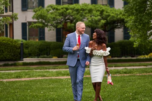 Free A couple elegantly dressed, enjoying a celebration outdoors with drinks in summer. Stock Photo