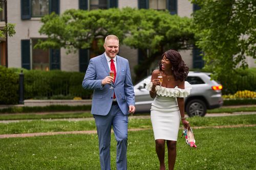 Free A happy couple enjoying a celebration in a park setting, sharing drinks and laughter. Stock Photo
