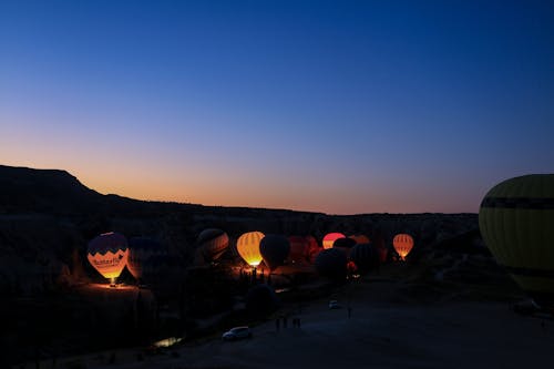 Illuminated Hot Air Balloons on the Ground in the Valley in Cappadocia, Turkey 