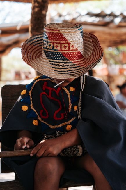 A child in vibrant traditional Guajira attire including a colorful hat and poncho in Colombia.