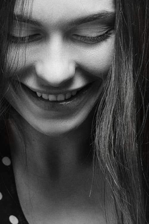 Close-up Picture of a Young Woman Looking Down and Smiling 