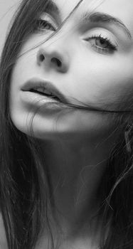 Serene black and white portrait of a young woman with soft lighting.