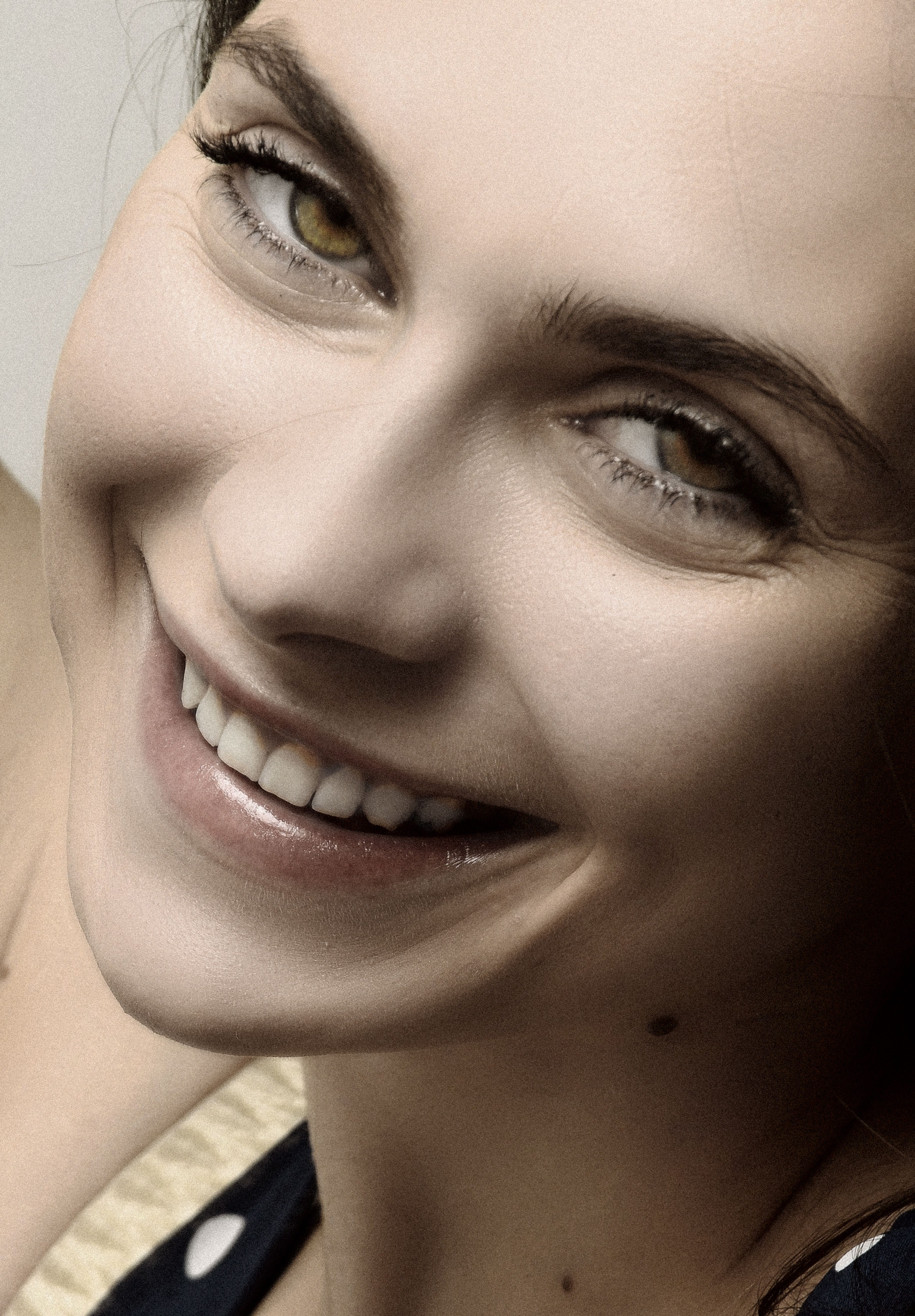 Close-up portrait of a smiling woman with a captivating gaze and natural beauty.