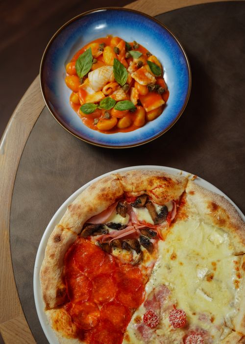 Free Top view of a colorful spread with assorted pizza slices and a vibrant plate of gnocchi. Stock Photo