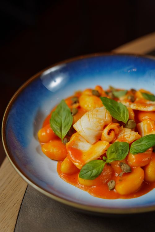 Free Close-up of pasta in red sauce garnished with basil leaves in ceramic bowl. Stock Photo