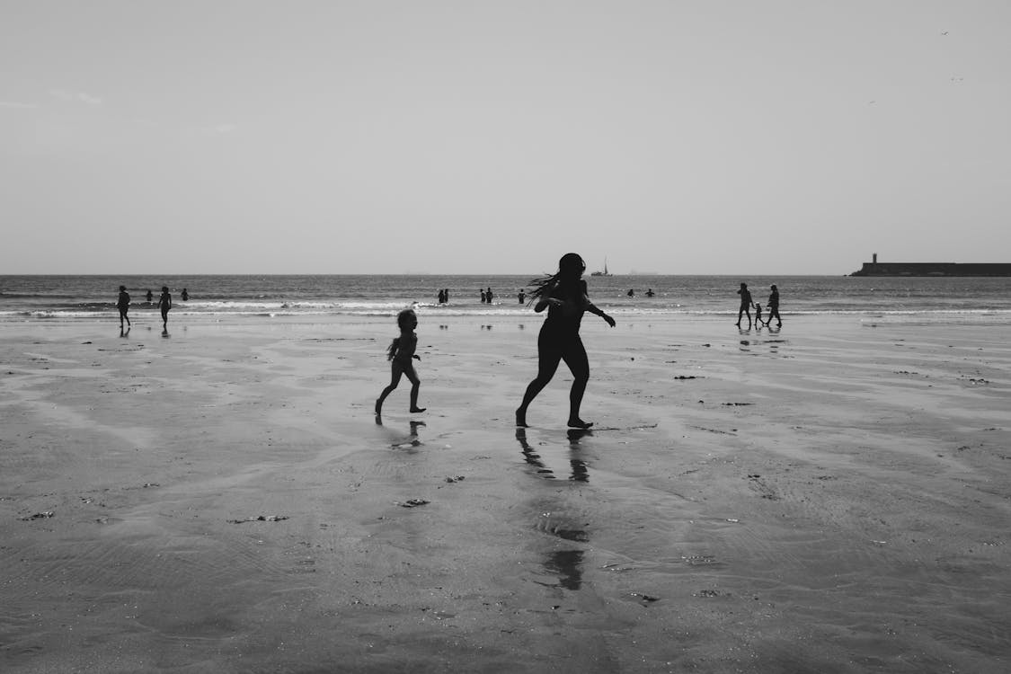 免费 人们在海滩上的灰度摄影 素材图片