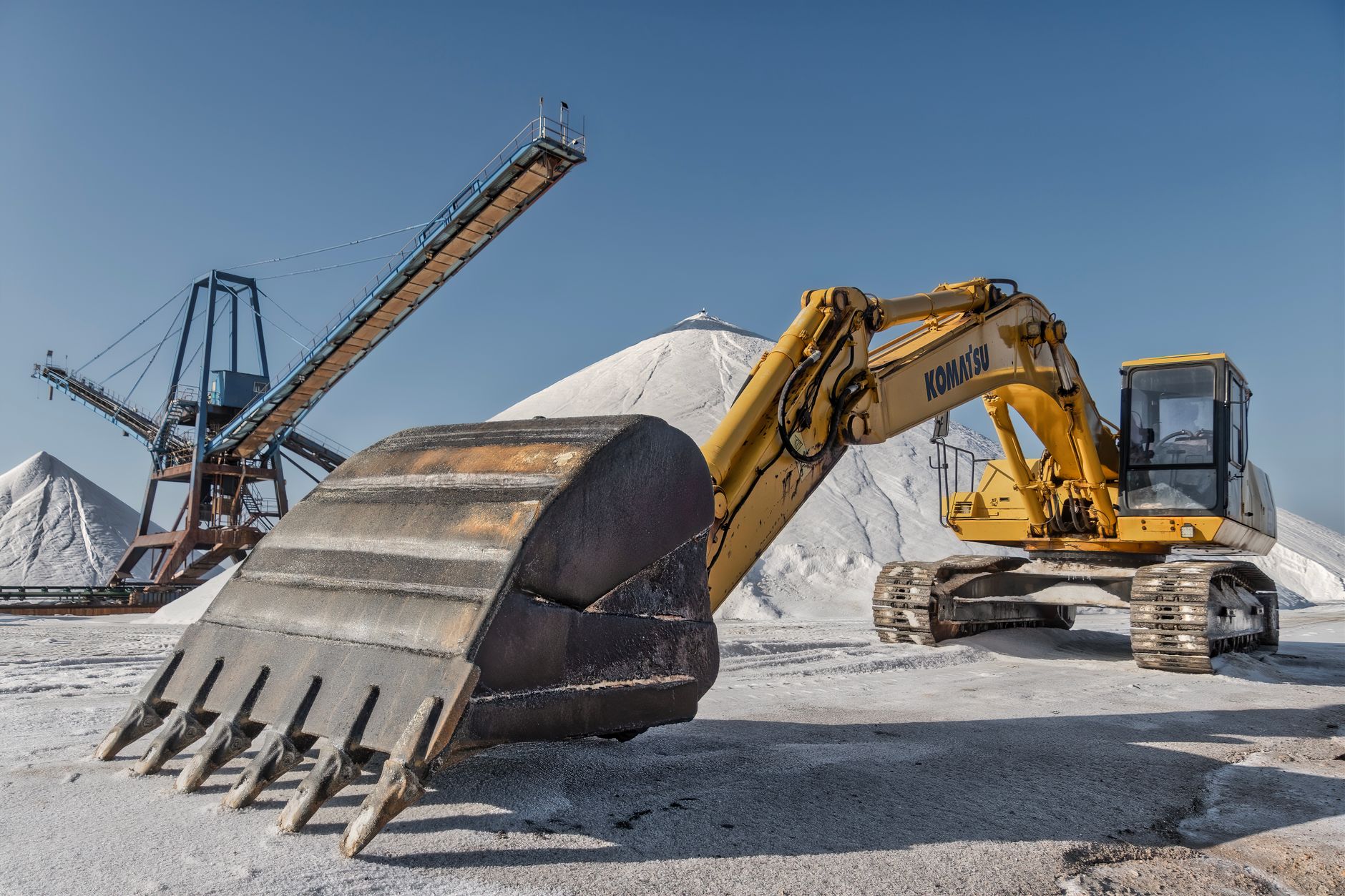 Excavator and conveyor system in a snowy quarry