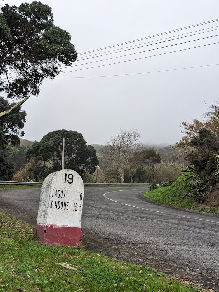 Stone Road Sign On Road Turn