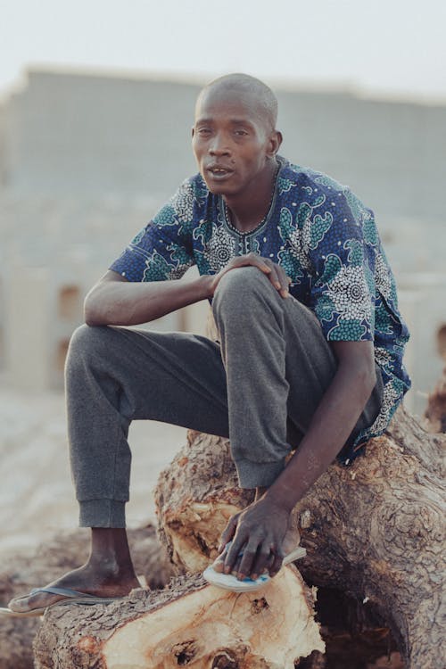 Man Sitting on Tree Trunk