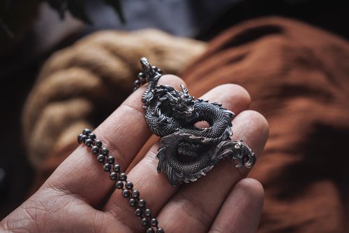 Free Close-up of hand holding a detailed Chinese dragon keychain, emphasizing Asian culture. Stock Photo