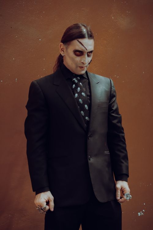 Free Eerie portrait of a man with ghostly makeup in a dark suit, perfect for Halloween themes. Stock Photo