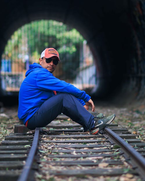 Foto profissional grátis de boné, casaco com capuz, estrada de ferro