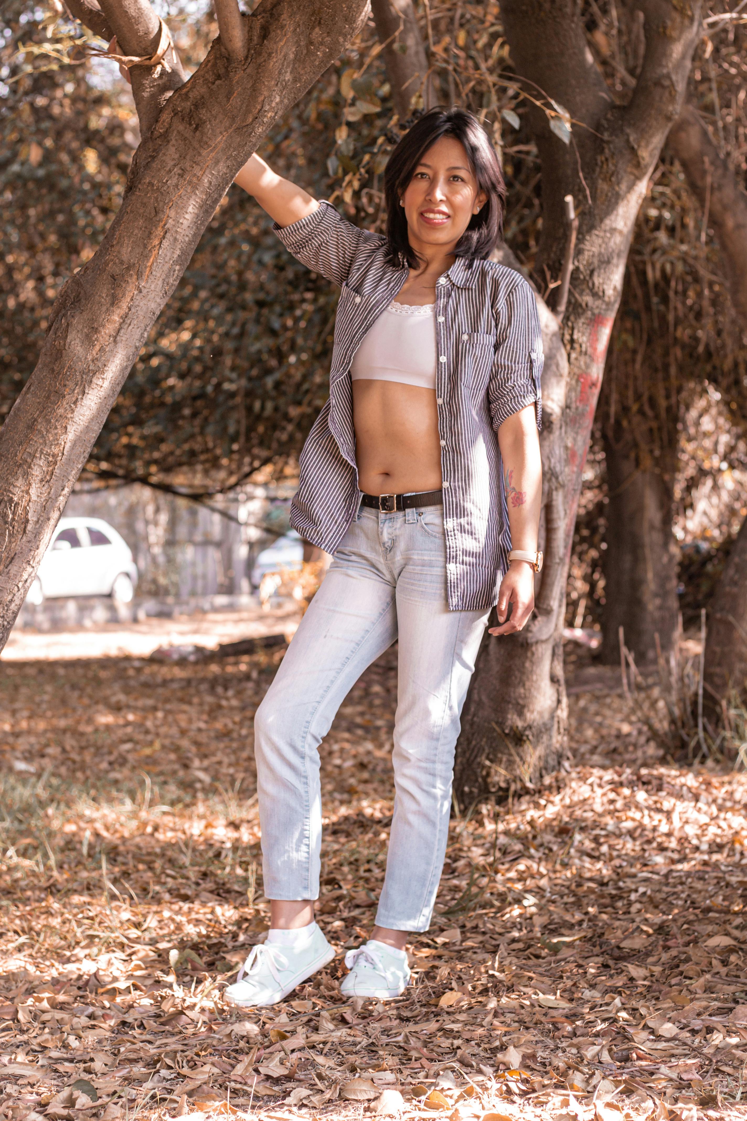Woman in Jeans Posing by Tree · Free Stock Photo