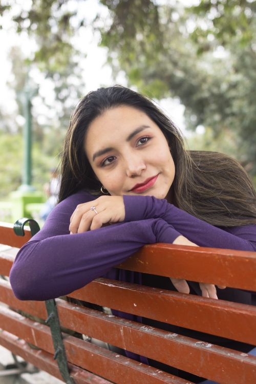 Free Beautiful woman sitting on a bench in Yanahuara, Peru, enjoying the outdoor scenery. Stock Photo