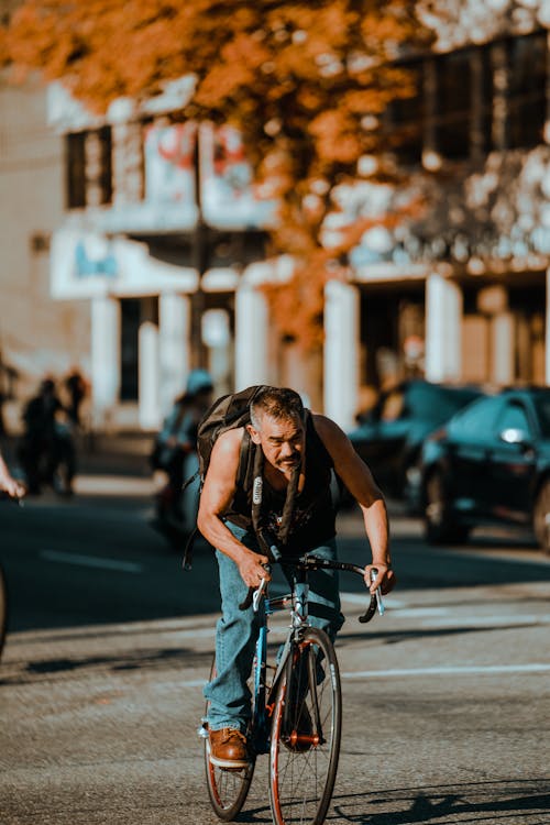 A Man Riding Bicycle in a City 