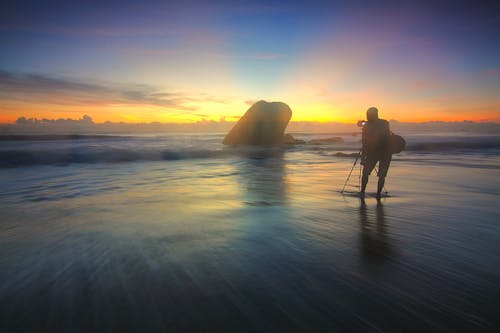 бесплатная Фотография силуэта человека на берегу моря Стоковое фото