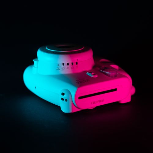 Free Artistic close-up of an instant camera with dynamic blue and red neon lighting on a black background. Stock Photo