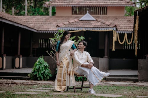 Man and Woman Wearing Traditional Clothing in Yard