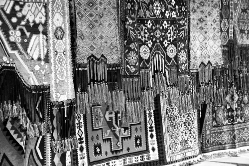 Free A vibrant display of intricately patterned carpets at a market stall. Stock Photo