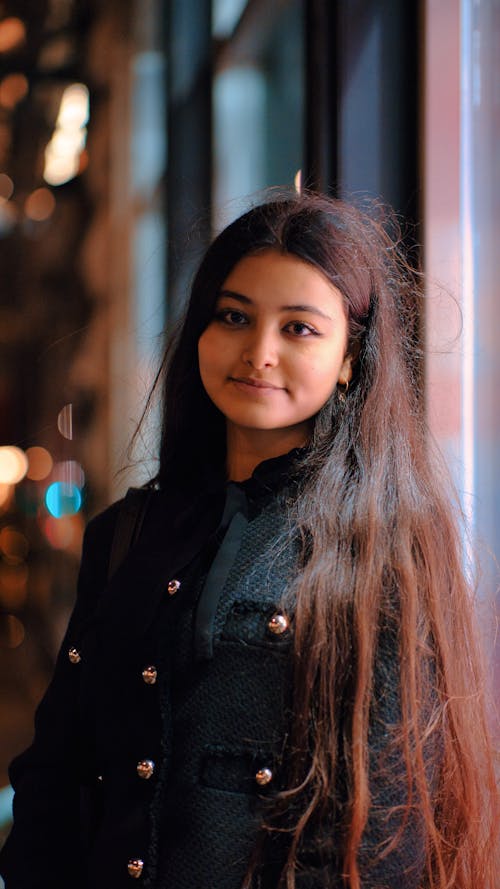 Woman with Long Hair Standing in City in the Evening 