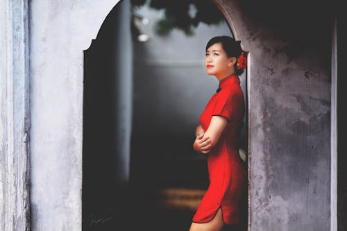 倚在牆上的紅色迷你連衣裙的女人