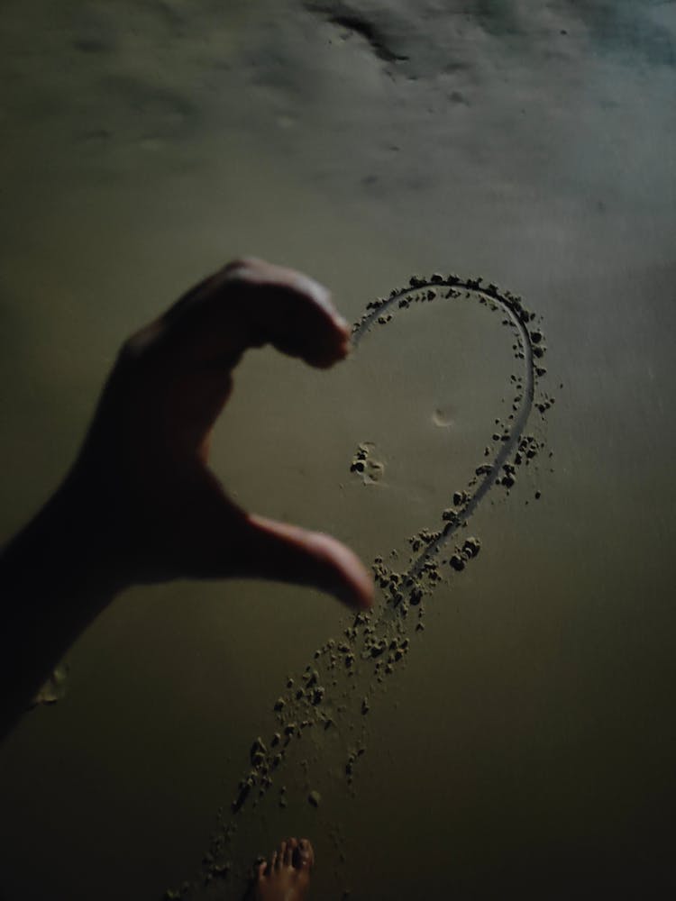 Hand Over Heart On Sand