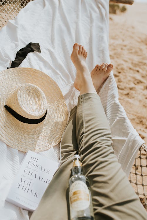 Free Person Resting in a Hammock with a Sun Hat and a Book Stock Photo