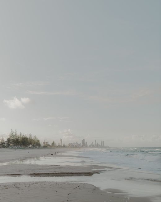 A tranquil morning view of Gold Coast beach with the city skyline in the distance.