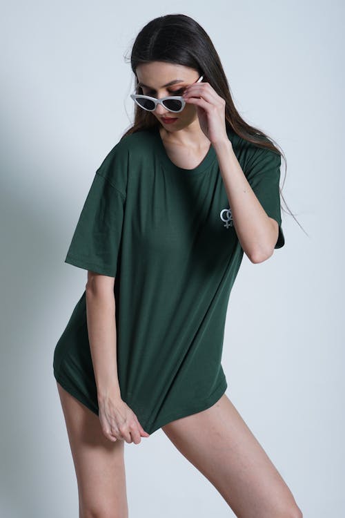 Woman Dressed in Green T-shirt and Sunglasses Posing in Studio