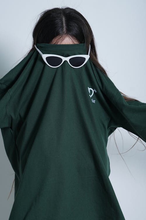 Woman Dressed in Sunglasses and T-shirt Posing on Studio 