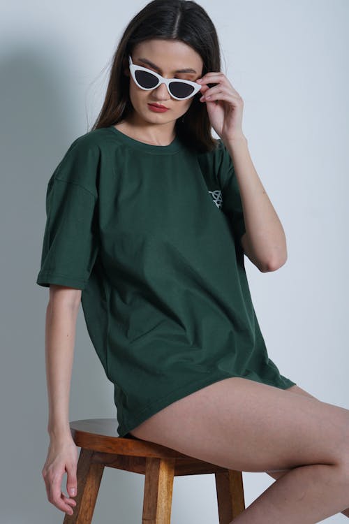 Young Woman in Sunglasses Posing in Studio on Bar Stool