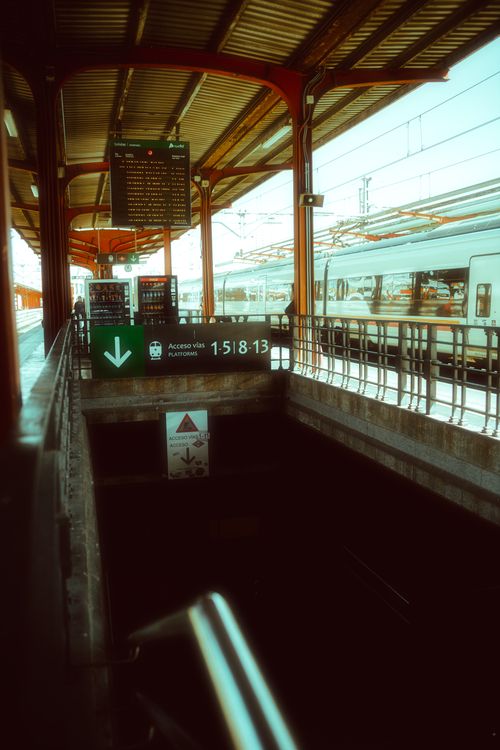 Free Railway station entrance in Madrid with stairs leading underground and trains in view. Stock Photo