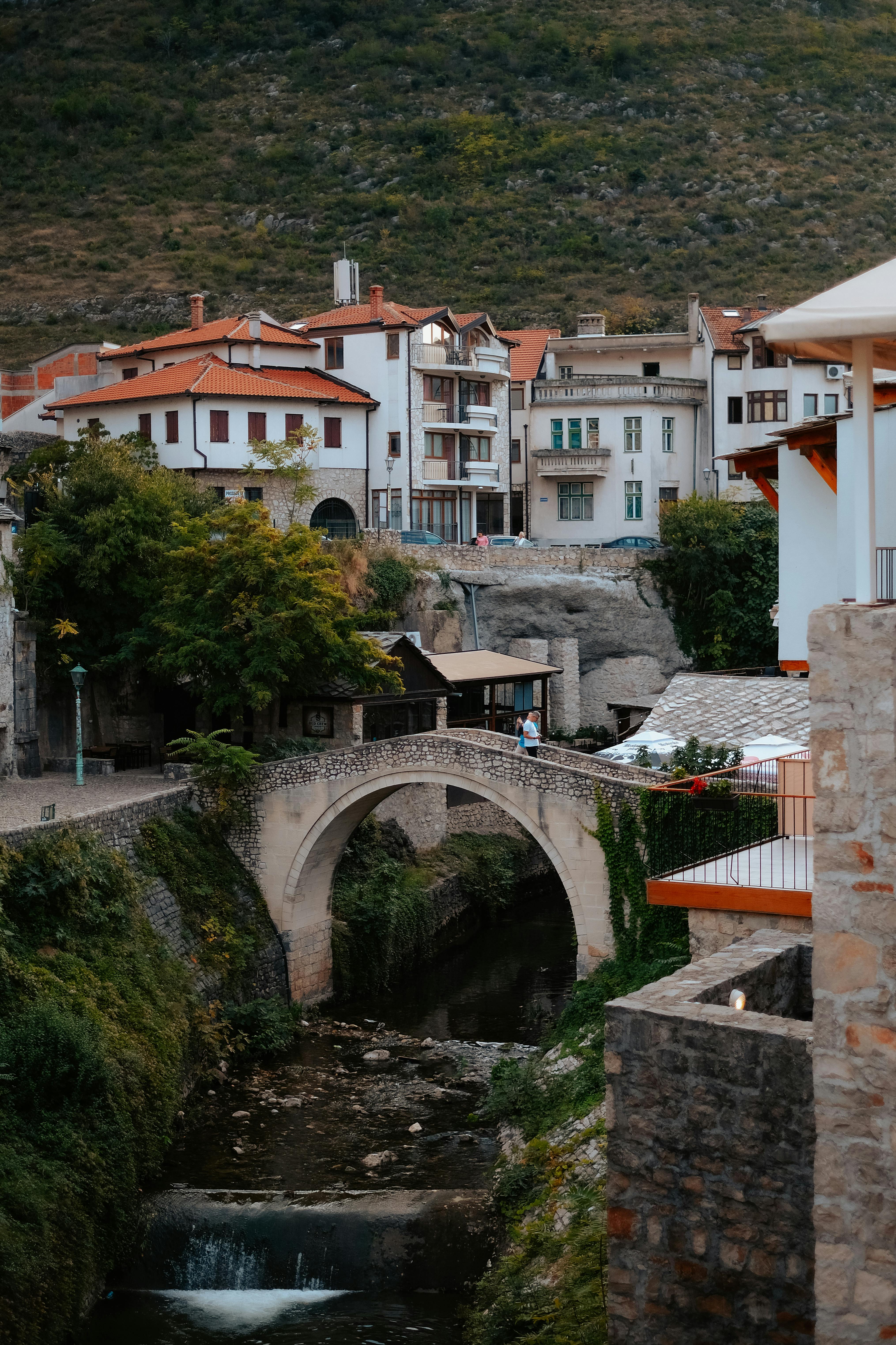 Picturesque view of a historic bridge in Mostar, Bosnia, showcasing local architecture and natural beauty.