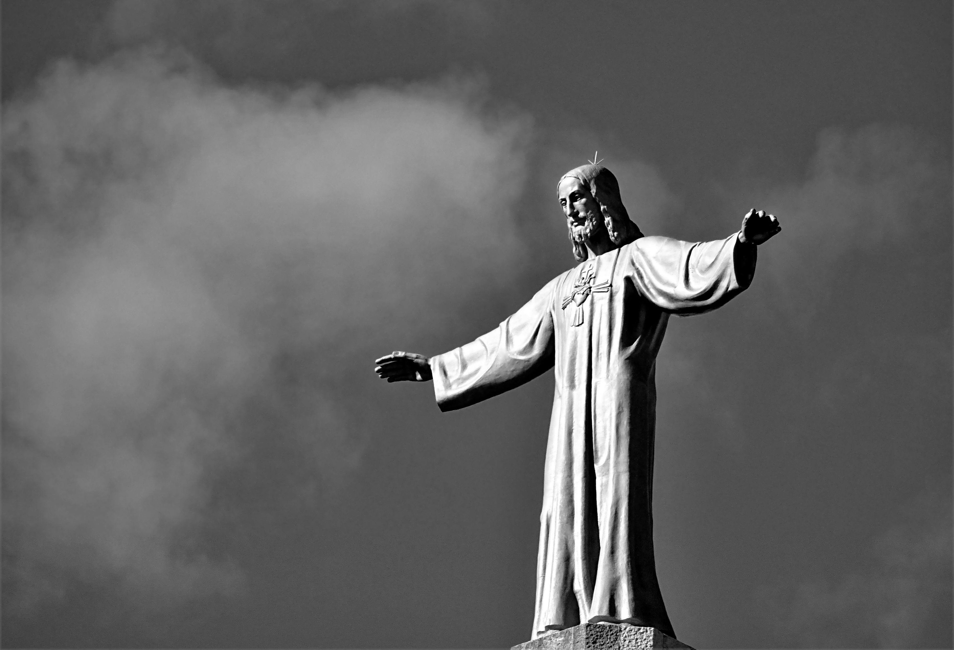 Black and white statue of Jesus Christ with outstretched arms against a cloudy sky, representing religious naming controversy and illegal baby names in court decisions.