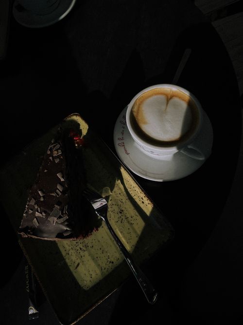 Free Sliced chocolate cake with cappuccino in cozy café lighting, captured indoors. Stock Photo