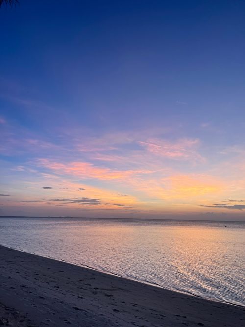 Free A serene sunset over the ocean at Guraidhoo, Maldives, reflecting pastel colors on the water's surface. Stock Photo