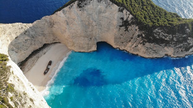 A breathtaking aerial view of Navagio Beach on Zakinthos Island, Greece, featuring vibrant blue waters and a shipwreck.