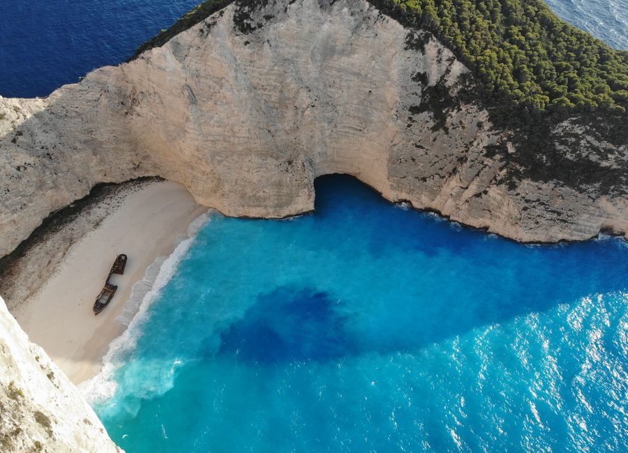 A breathtaking aerial view of Navagio Beach on Zakinthos Island, Greece, featuring vibrant blue waters and a shipwreck.