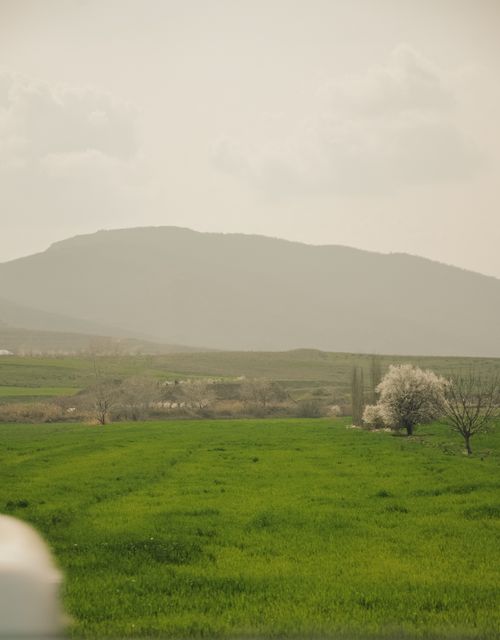 Free Green fields and distant hills under a misty sky in Quba, Azerbaijan, showcasing serene nature. Stock Photo