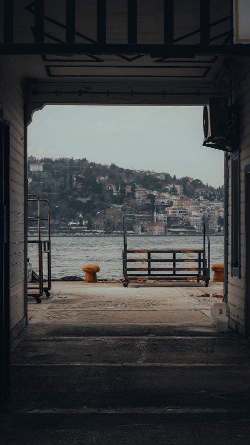 Free A captivating view of an urban harbor framed by a passageway, perfect for travel and architecture themes. Stock Photo