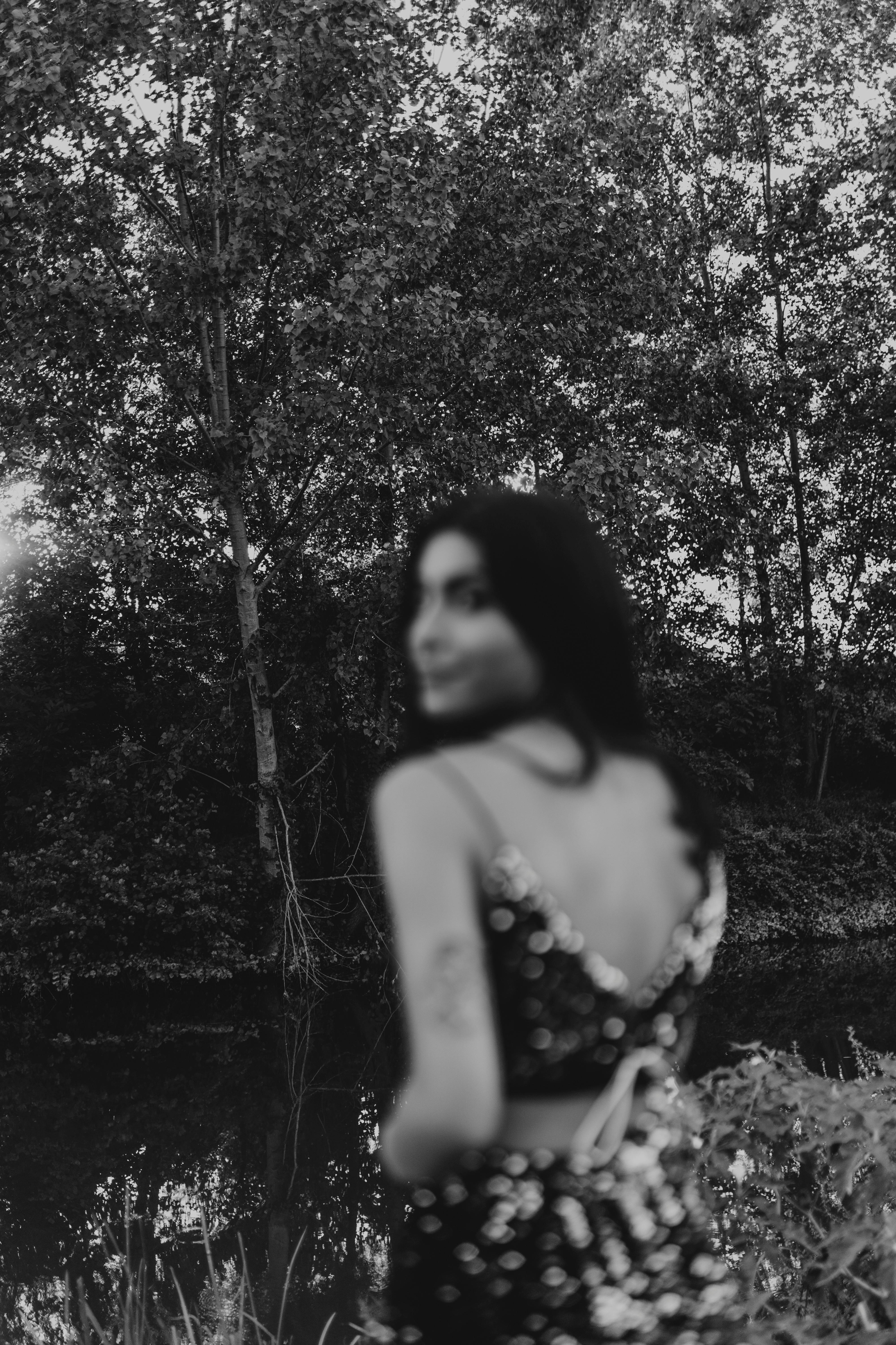 Blurred silhouette of a woman in a forest by a river, İstanbul, Türkiye.