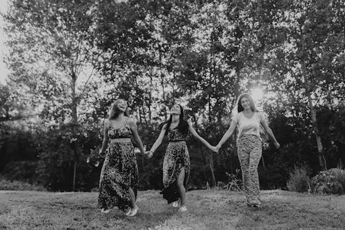 Photo of Three Young Women Holding Hands