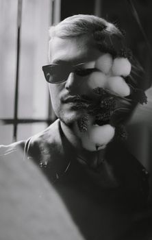 Creative portrait with a black and white double exposure effect featuring a man and flowers.
